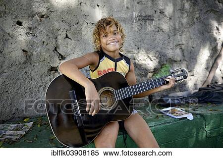 "Girl, 11, holding a guitar, having guitar lessons as part of the Sao Martinho social project for street children, Lapa district, Rio de Janeiro, Rio de Janeiro State, Brazil, South America" View Large Photo Image Stock Photography - "Girl, 11, holding a guitar, having guitar lessons as part of the Sao Martinho social project for street children, Lapa district, Rio de Janeiro, Rio de Janeiro State, Brazil, South America". Fotosearch