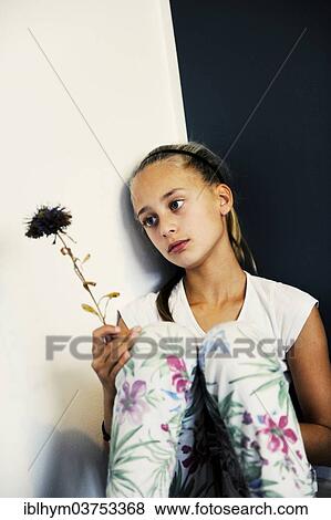"Girl, 11 years, holding a wilted flower, lost in thought" View Large Photo Image Stock Photo - "Girl, 11 years, holding a wilted flower, lost in thought". Fotosearch