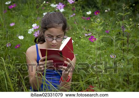"Girl, 11 years, reading a book sitting in a flower meadow" View Large Photo Image Stock Photo - "Girl, 11 years, reading a book sitting in a flower meadow". Fotosearch
