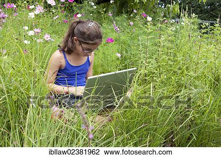 "Girl, 11 years, sitting on a meadow working on a laptop computer" View Large Photo Image Stock Image - "Girl, 11 years, sitting on a meadow working on a laptop computer". Fotosearch