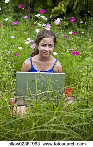 "Girl, 11 years, sitting on a meadow with a laptop computer" View Large Photo Image Stock Image - "Girl, 11 years, sitting on a meadow with a laptop computer". Fotosearch