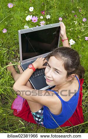 "Girl, 11 years, sitting on a meadow with a laptop computer" View Large Photo Image Stock Photograph - "Girl, 11 years, sitting on a meadow with a laptop computer". Fotosearch