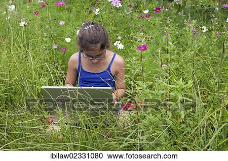 "Girl, 11 years, working on a laptop computer, notebook, sitting in a flower meadow" View Large Photo Image Stock Image - "Girl, 11 years, working on a laptop computer, notebook, sitting in a flower meadow". Fotosearch
