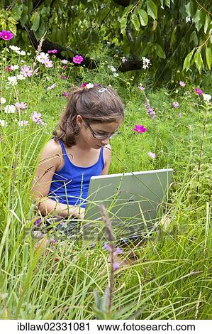 "Girl, 11 years, working on a laptop computer, notebook, sitting in a flower meadow" View Large Photo Image Stock Image - "Girl, 11 years, working on a laptop computer, notebook, sitting in a flower meadow". Fotosearch