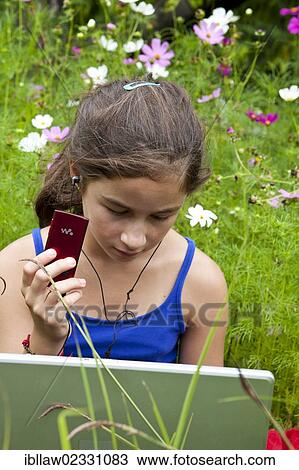 "Girl, 11 years, working on a laptop computer, notebook, listening to music, sitting in a flower meadow" View Large Photo Image Stock Image - "Girl, 11 years, working on a laptop computer, notebook, listening to music, sitting in a flower meadow". Fotosearch