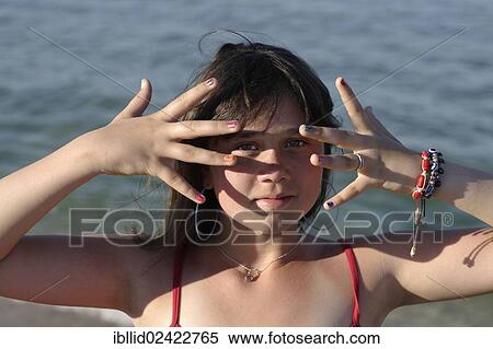 Stock Photography - Girl, 12, showing her colourful painted fingernails. Fotosearch