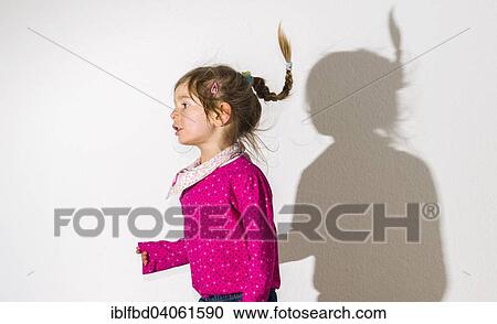 "Girl, 3 years, wearing a pink shirt, dancing, casting a shadow on a white wall" View Large Photo Image Stock Image - "Girl, 3 years, wearing a pink shirt, dancing, casting a shadow on a white wall". Fotosearch