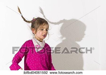 "Girl, 3 years, wearing a pink shirt, dancing, casting a shadow on a white wall" View Large Photo Image Stock Image - "Girl, 3 years, wearing a pink shirt, dancing, casting a shadow on a white wall". Fotosearch