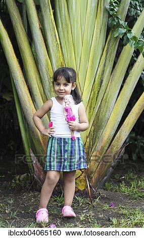 "Girl, 4 years, holding a Barbie doll, posing in front of a palm tree, San Juan de Nicaragua or San Juan del Norte or Greytown, Rio San Juan, Nicaragua, North America" View Large Photo Image Stock Image - "Girl, 4 years, holding a Barbie doll, posing in front of a palm tree, San Juan de Nicaragua or San Juan del Norte or Greytown, Rio San Juan, Nicaragua, North America". Fotosearch