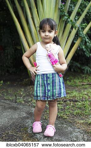 "Girl, 4 years, holding a Barbie doll, posing in front of a palm tree, San Juan de Nicaragua or San Juan del Norte or Greytown, Rio San Juan, Nicaragua, North America" View Large Photo Image Stock Photo - "Girl, 4 years, holding a Barbie doll, posing in front of a palm tree, San Juan de Nicaragua or San Juan del Norte or Greytown, Rio San Juan, Nicaragua, North America". Fotosearch