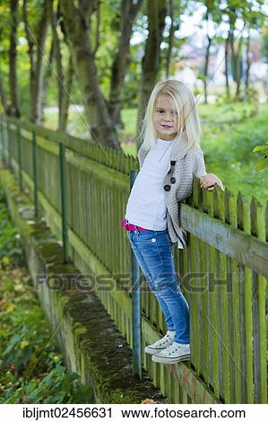 "Girl, 4 years old, leaning against a wooden fence" View Large Photo Image Stock Image - "Girl, 4 years old, leaning against a wooden fence". Fotosearch