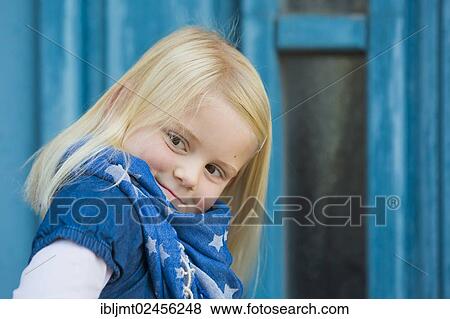 Stock Photo - "Girl, 4 years old, sitting in front of a blue door". Fotosearch