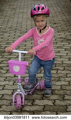 Stock Image - "Girl, 4 years, with a scooter, Ystad, Sweden, Europe". Fotosearch