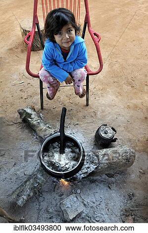 "Girl, 5, sitting at a fireplace with a pot of porridge, in a community of the Guarani Indians, Jaguary, Caaguazu Department, Paraguay, South America" View Large Photo Image Stock Image - "Girl, 5, sitting at a fireplace with a pot of porridge, in a community of the Guarani Indians, Jaguary, Caaguazu Department, Paraguay, South America". Fotosearch
