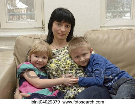 "Girl, 5 years, boy, 7 years with their mother, 35 years, sitting on a sofa" View Large Photo Image Stock Photo - "Girl, 5 years, boy, 7 years with their mother, 35 years, sitting on a sofa". Fotosearch