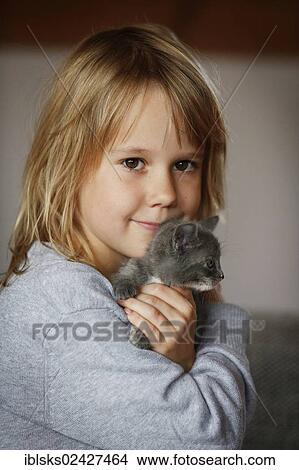 Picture - "Girl, 7 years, cuddling a kitten, portrait". Fotosearch