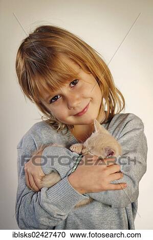 Stock Image - "Girl, 7 years, cuddling a kitten, portrait". Fotosearch