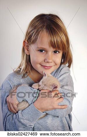 Stock Photo - "Girl, 7 years, cuddling a kitten, portrait". Fotosearch