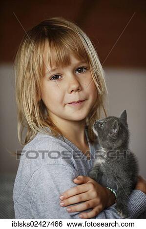 Stock Photograph - "Girl, 7 years, cuddling a kitten, portrait". Fotosearch