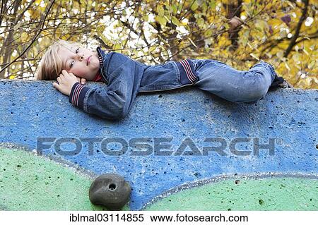 Stock Photography - "Girl, 7 years, lying on top of a climbing wall, Esslingen, Baden-Wurttemberg, Germany, Europe". Fotosearch