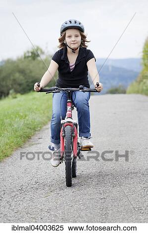 "Girl, 8 years, riding a bicycle wearing a helmet" View Large Photo Image Stock Photography - "Girl, 8 years, riding a bicycle wearing a helmet". Fotosearch