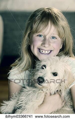 "Girl, 9, cuddling with a young mixed-breed dog" View Large Photo Image Stock Image - "Girl, 9, cuddling with a young mixed-breed dog". Fotosearch