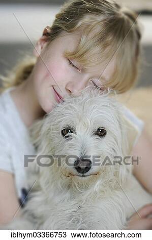 Stock Image - "Girl, 9, cuddling with a young mixed-breed dog". Fotosearch