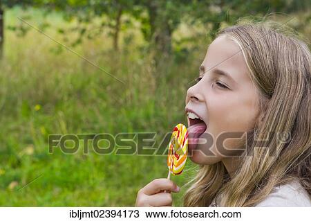 "Girl, 9, licking a colourful lollipop" View Large Photo Image Stock Image - "Girl, 9, licking a colourful lollipop". Fotosearch