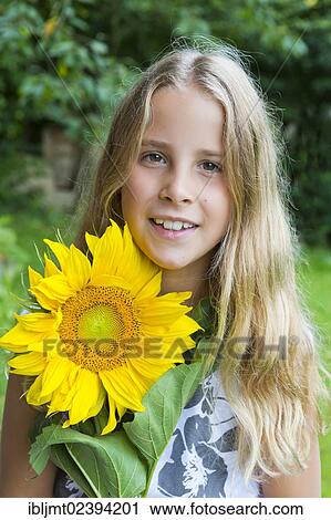 "Girl, 9, portrait holding a sunflower" View Large Photo Image Stock Image - "Girl, 9, portrait holding a sunflower". Fotosearch