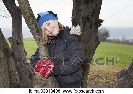 "Girl, 9, wearing a hat and gloves, on a tree" View Large Photo Image Stock Photo - "Girl, 9, wearing a hat and gloves, on a tree". Fotosearch