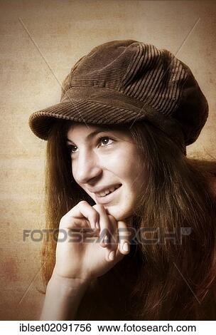 Stock Photograph - "Girl, aged 13, wearing a brown cap, smiling, portrait". Fotosearch