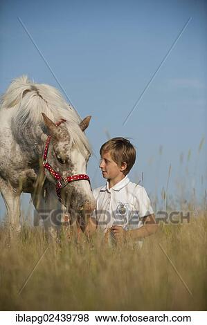 Stock Photo - Girl and a pony in a meadow. Fotosearch