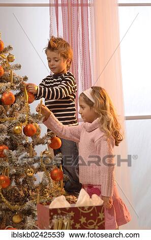 Girl and boy lighting candles of a festively decorated Christmas tree View Large Photo Image Stock Photo - Girl and boy lighting candles of a festively decorated Christmas tree. Fotosearch