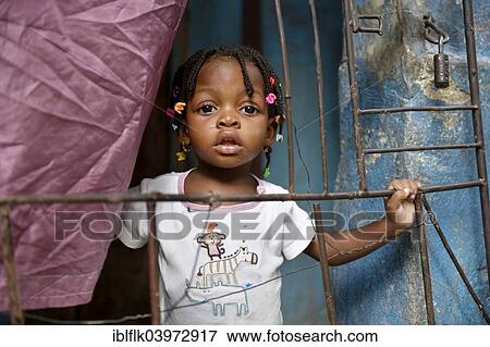 "Girl behind a fence in a doorway, Fort National slum, Port-au-Prince, Haiti, North America" View Large Photo Image Stock Photo - "Girl behind a fence in a doorway, Fort National slum, Port-au-Prince, Haiti, North America". Fotosearch