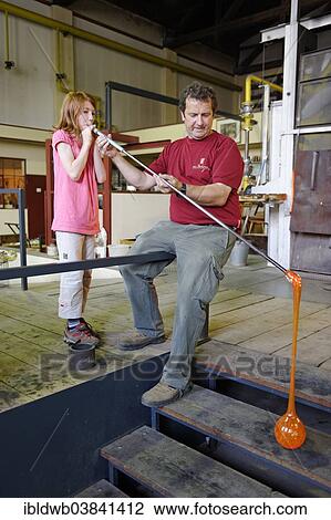 Stock Image - "Girl blowing a garden glass ball, glazier's workshop, Glashutte Freiherr von Poschingerstrasse, Frauenau, Lower Bavaria, Bavaria, Germany, Europe". Fotosearch