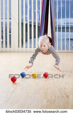 Girl during a coordination exercise with small balls while swinging in a hammock View Large Photo Image Stock Photography - Girl during a coordination exercise with small balls while swinging in a hammock. Fotosearch