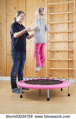 Stock Photo - Girl during jump training on a trampoline. Fotosearch
