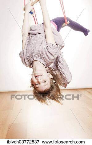 Stock Photo - Girl exercising on a swing. Fotosearch
