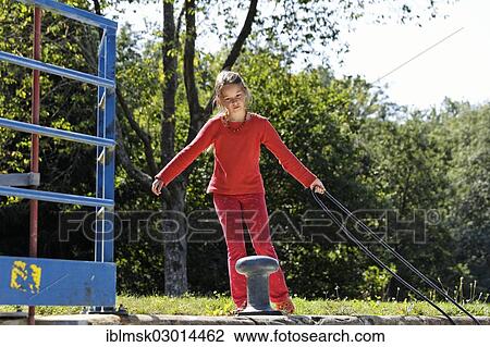Stock Image - "Girl fastening a rope to secure the boat in the lock chamber, houseboat on the Canal des Vosges, formerly Canal de l'Est, at Lock 15, PK 106, Uzemain, Epinal, Lorraine, Departement Vosges, France, Europe". Fotosearch