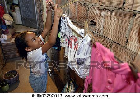"Girl hanging laundry on a clothesline in a slum or favela, Jacarezinho favela, Rio de Janeiro, Rio de Janeiro State, Brazil, South America" View Large Photo Image Stock Image - "Girl hanging laundry on a clothesline in a slum or favela, Jacarezinho favela, Rio de Janeiro, Rio de Janeiro State, Brazil, South America". Fotosearch