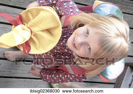 Stock Image - Girl holding a school cone. Fotosearch