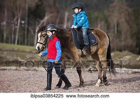 "Girl leading a pony with a young child riding it, dun, with a bridle, Tyrol, Austria, Europe" View Large Photo Image Stock Photography - "Girl leading a pony with a young child riding it, dun, with a bridle, Tyrol, Austria, Europe". Fotosearch