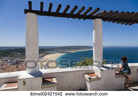 Stock Image - Girl looking at the beach, Praia, from Sitio, Nazare, Oeste, Leiria District, Portugal, Europe. Fotosearch