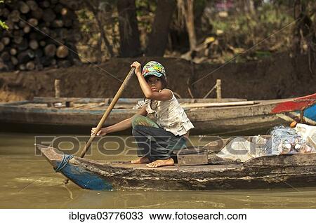 "Girl paddling a traditional boat on the Sangker river in Battambang, Battambang Province, Cambodia, Asia" View Large Photo Image Stock Image - "Girl paddling a traditional boat on the Sangker river in Battambang, Battambang Province, Cambodia, Asia". Fotosearch