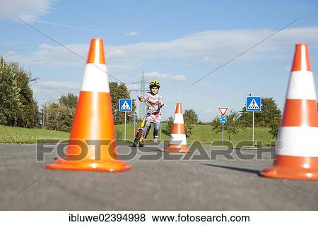 Girl practicing to ride slalom on a scooter at a traffic awareness course View Large Photo Image Stock Photo - Girl practicing to ride slalom on a scooter at a traffic awareness course. Fotosearch