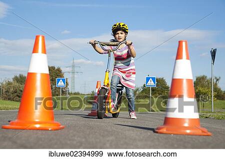 Girl practicing to ride slalom on a scooter at a traffic awareness course View Large Photo Image Stock Photo - Girl practicing to ride slalom on a scooter at a traffic awareness course. Fotosearch