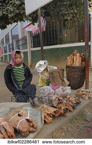 Stock Image - "Girl selling agarwood or oodh, incense, on the market of Phonsavan, Laos, Southeast Asia, Asia". Fotosearch