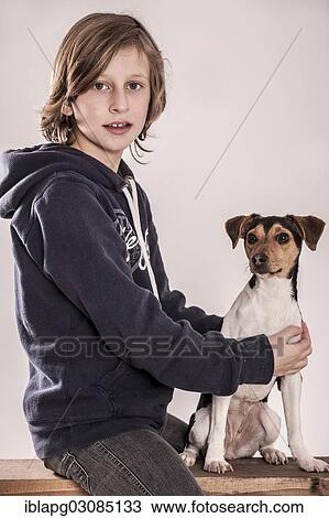Stock Image - Girl sitting on a bench with a Danish Swedish Farmdog. Fotosearch