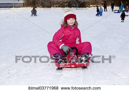 "Girl sitting on a sled, Baden Wuerttemberg, Germany, Europe" View Large Photo Image Stock Photo - "Girl sitting on a sled, Baden Wuerttemberg, Germany, Europe". Fotosearch