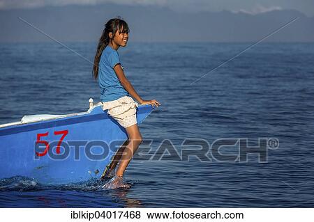 Stock Photo - "Girl sitting on small fishing boat, Lovina Bay, Bali, Indonesia, Asia". Fotosearch